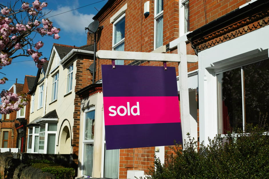 English suburban house with 'sold' sign.